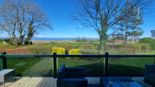 a balcony with a view of a field at Sea views, fabulous modern lodge in Port Seton