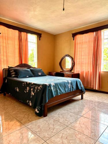 a bedroom with a bed and a mirror and windows at Transit Home - 10 mins from airport in Mare dʼAlbert