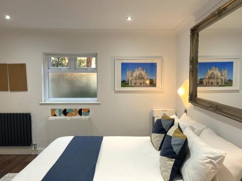 a bedroom with a bed and two windows at Melbury Rooms & Studios in Exeter