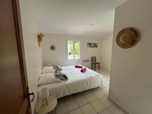 索列图卡Villa aux portes de la Sainte Baume的卧室里有一张铺着白色床单的床和一扇窗户