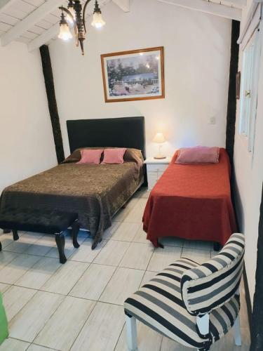 ein Schlafzimmer mit 2 Betten und einem Stuhl darin in der Unterkunft Los Delfines 2 in Mar de las Pampas