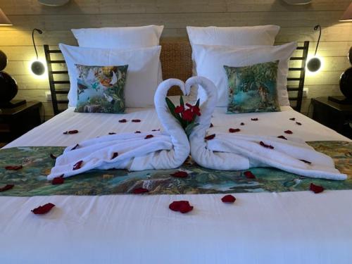 two swans made out of towels on a bed at Cabane d'Amour in Béziers