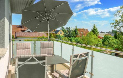 a pair of chairs and an umbrella on a balcony at Ferienwohnung Karlshagen in Ostseebad Karlshagen