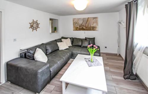 a living room with a black leather couch and a table at Ferienwohnung Graal-Müritz in Graal-Müritz