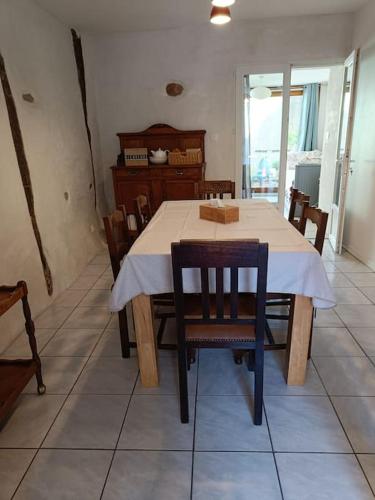 a dining room table with chairs and a white tablecloth on it at Les lits de Montbel gîte in Sonnac-sur-lʼHers