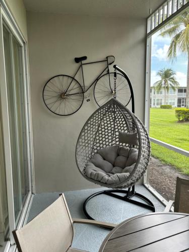 a bike hanging on a porch with a swing at GreenLinks Luxury Villa at Lely Resort Golf - 3 Bedrooms in Naples