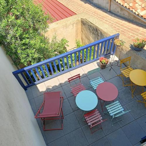 a patio with tables and chairs and a blue railing at Les lits de Montbel gîte in Sonnac-sur-lʼHers