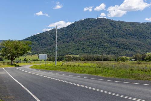 an empty road with a mountain in the background at studio on Jasmine in Bomaderry