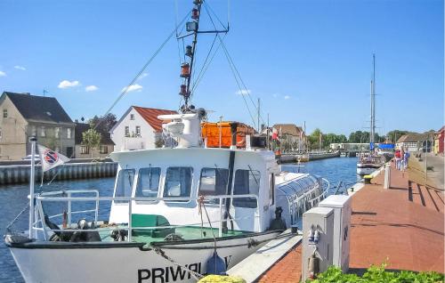 a boat is docked at a dock in the water at Ferienhaus Ueckermünde Seebad in Neuendorf