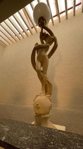 a statue of a woman holding a light on a table at Pousada Conviver in Juazeiro do Norte