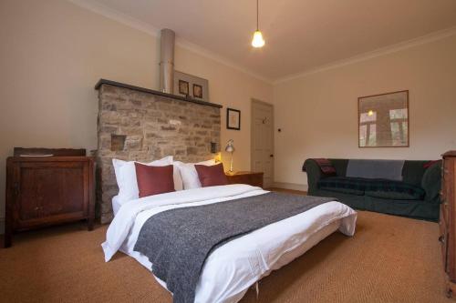 a bedroom with a large bed and a couch at Woodlands House in Giggleswick