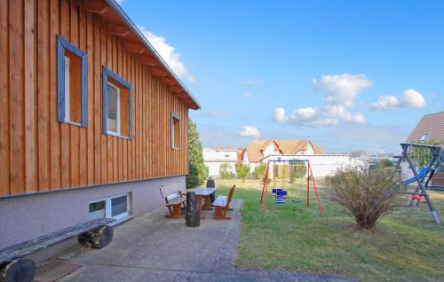 una casa con un parque infantil al lado de un edificio en Ferienhaus Trassenheide, en Trassenheide