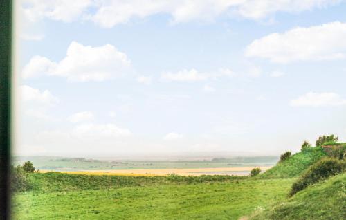 a painting of a green hill with a view of a field at Nice Home In Lemvig With Wifi in Lemvig