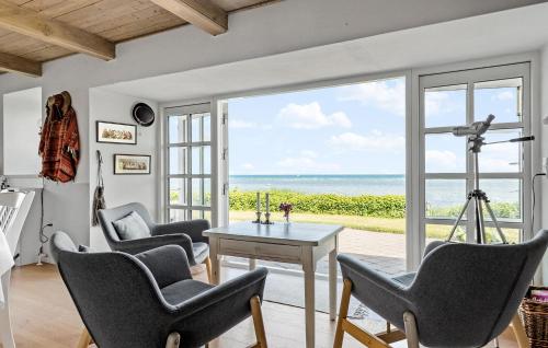 a living room with chairs and a table and a view of the ocean at Gorgeous Home In Glesborg With Wifi in Glesborg