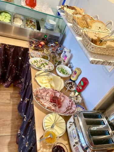 a buffet of food with bread and other foods at Pod Różą B&B in Ustka