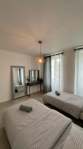 une chambre avec deux lits et un miroir dans l'établissement Appartement neuf, centre-ville, 400m de rivetoile 6 voyageurs, à Strasbourg