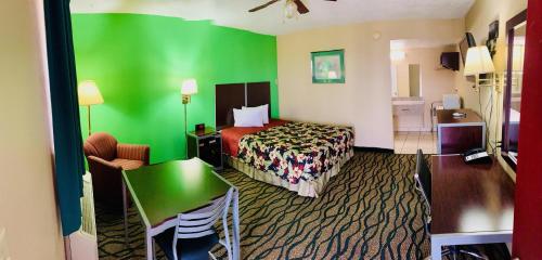 a hotel room with a bed and a green wall at Thunderbird Inn in Liberal