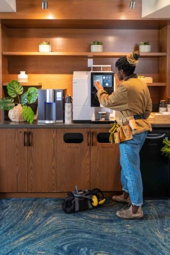 a woman is standing in front of a microwave at Accent Inns Burnaby in Burnaby