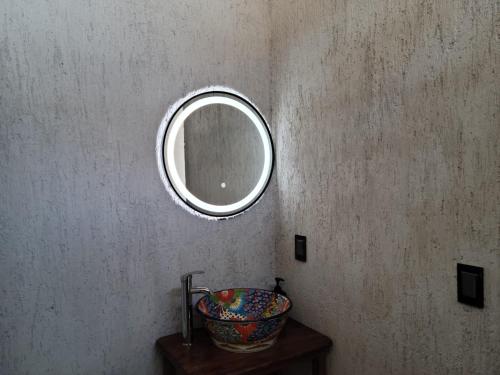 a bathroom with a mirror and a bowl on a table at Puerto del Cielo in Chuburná