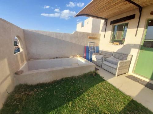 a backyard with a large tub in the grass at בקתה וטבילה במדבר in H̱aẕeva