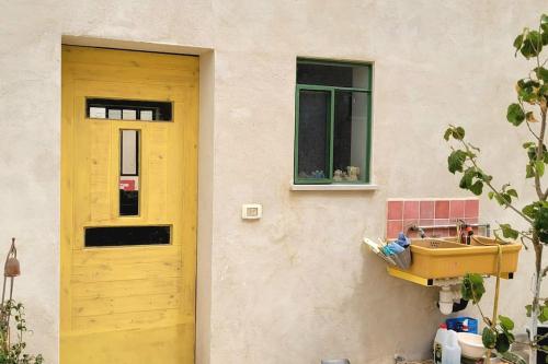 a yellow sink on the side of a building at בקתה וטבילה במדבר in H̱aẕeva