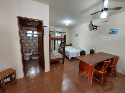 a room with a table and a bunk bed at Chalés Xibayka Ilhabela in Ilhabela