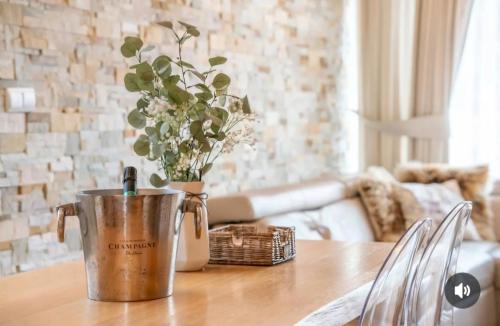 a metal bucket on a table with a vase of flowers at Chalet Rebeca 6 beds Donovaly in Donovaly