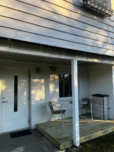 a porch with two chairs and a table on a house at Apartments near Bergen Airport in Bergen