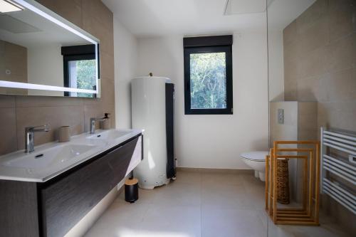 a bathroom with a sink and a toilet at Bonifacio Les Jardins ensoleillés de Piale in Bonifacio