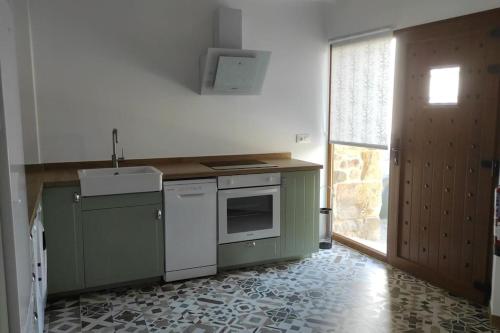 a kitchen with green and white appliances and a window at VillaManuela Vivienda Rural in San Vicente de Toranzo
