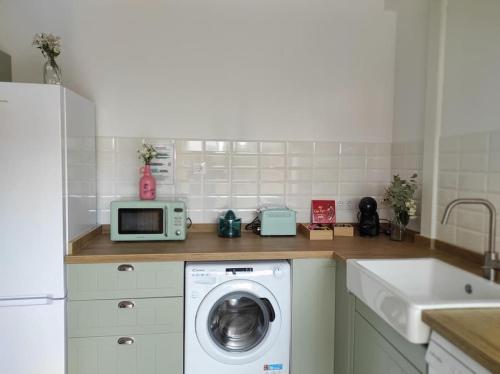 a kitchen with a washing machine and a microwave at VillaManuela Vivienda Rural in San Vicente de Toranzo
