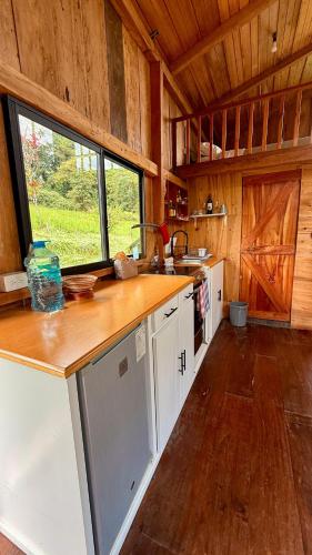 a kitchen with white cabinets and a large window at Villa Elena Sumaco in San Francisco de Borja