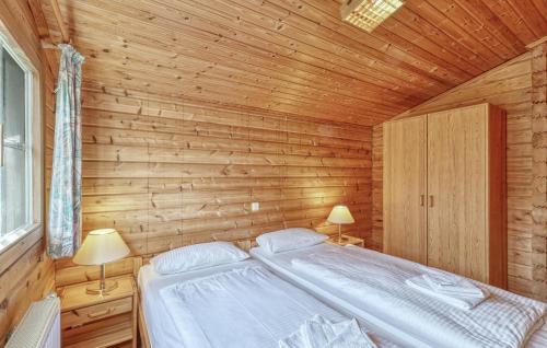 a bedroom with a bed in a wooden wall at 2 Bedroom Stunning Home In Masserberg in Fehrenbach
