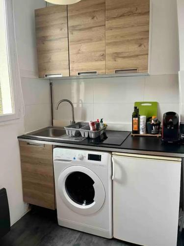 a kitchen with a washing machine and a sink at La Cachette du Roi in Fontainebleau