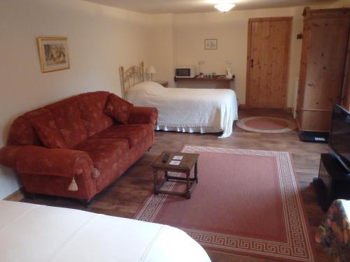 - un salon avec un canapé et un lit dans l'établissement The Courtyard, Laurel Farm, à Lowestoft