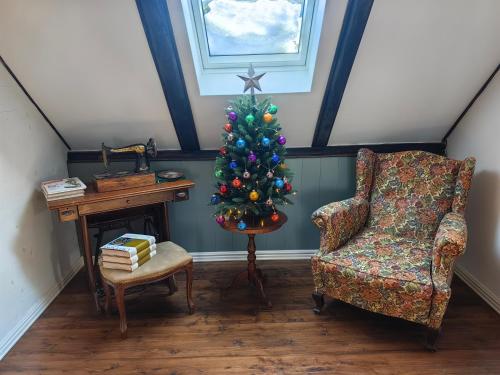 a living room with a christmas tree and a chair at Hiša Hortenzija Luče in Luče