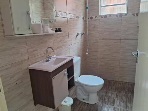 a bathroom with a toilet and a sink at Espaço Tranquilo-preço até 4 hóspedes in Pôrto Feliz