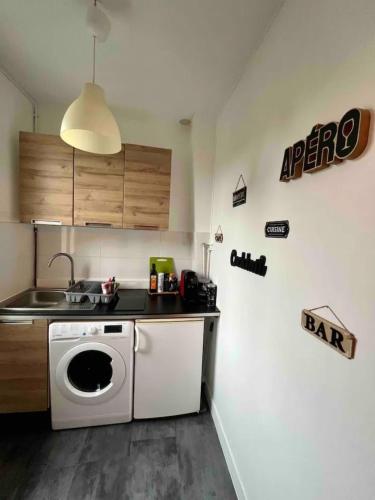 a kitchen with a washing machine and a sink at La Cachette du Roi in Fontainebleau