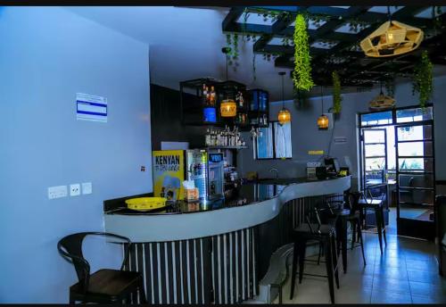 内罗毕2Bedroom BnB Apartment in Tatu City的餐厅内的酒吧配有黑色椅子和蓝色灯光
