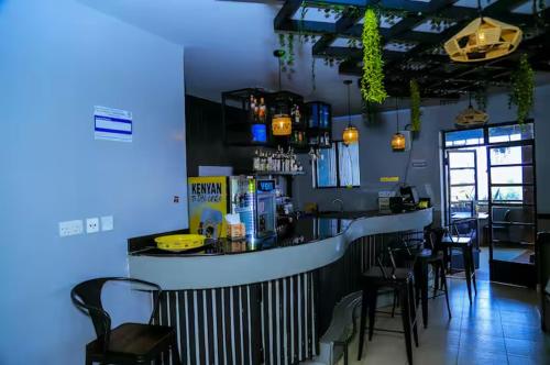 内罗毕2Bedroom BnB Apartment in Tatu City的餐厅内的酒吧配有黑色椅子和蓝色灯光