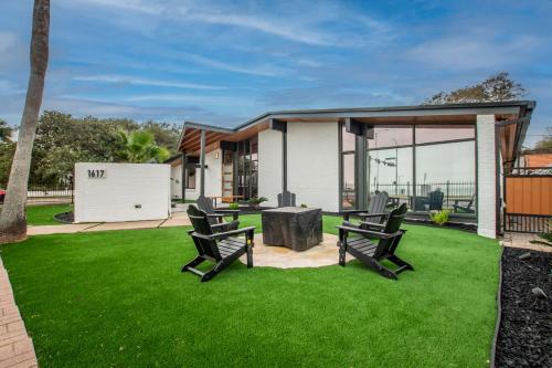 a lawn with two chairs in front of a house at Luxury on Ocean Drive - Sleeps 28 in Corpus Christi