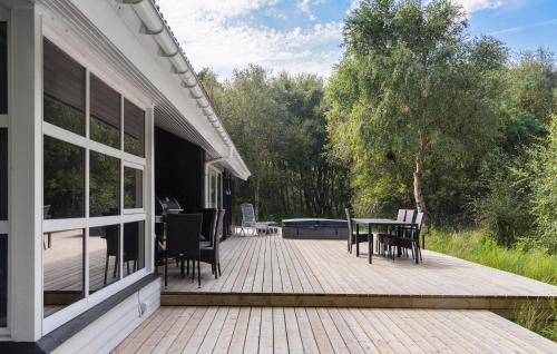 a deck with a table and chairs on a house at Cozy Home In Hirtshals With Kitchen in Hirtshals