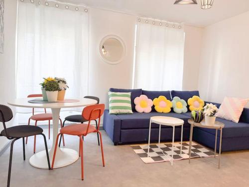 Una sala de estar con un sofá azul y una mesa y sillas. en Le JOY, centre ville, en Mulhouse