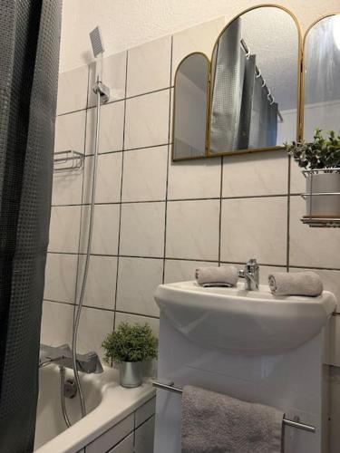 une salle de bain blanche avec un lavabo et un miroir dans l'établissement Le JOY, centre ville, à Mulhouse