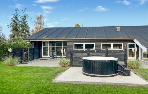 a house with a black roof with a trash can in front of it at Gorgeous Home In Væggerløse With Sauna in Marielyst