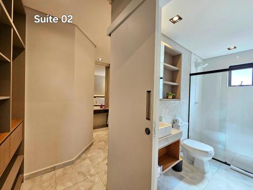 une salle de bain avec toilettes, douche et lavabo dans l'établissement Centro 2 quartos 2 banheiros - alto padrao novo, à Foz do Iguaçu