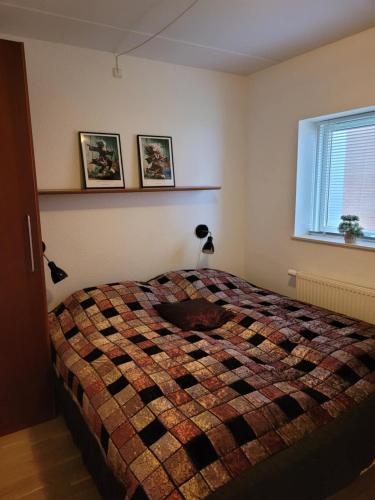 a bedroom with a bed with a quilt on it at Hejlsminde ferie- og badeby in Hejls