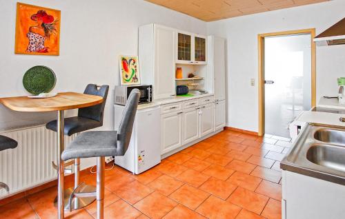 a kitchen with white cabinets and a table with chairs at Ferienwohnung Röbelmüritz in Röbel