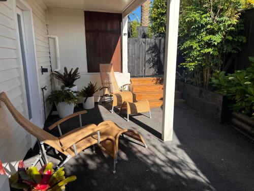 un grupo de sillas sentadas en un porche en Studio by the bays, en Auckland