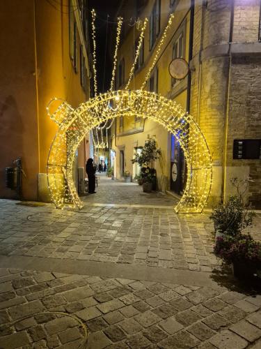 an arch decorated with lights in a street at night at Palazzo Tancredi in Ancona